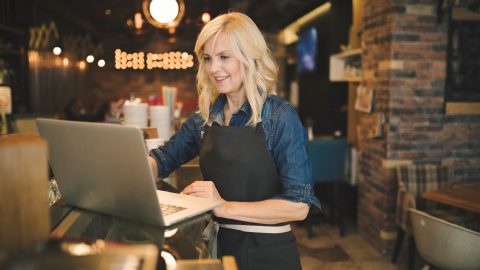 Coffee shop owner working on laptop